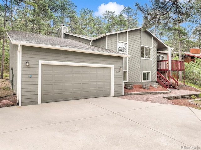 510 Silhouette Way, Monument, CO 80132 - view of front of home featuring concrete driveway, stairway, a chimney, a deck, and an attached garage