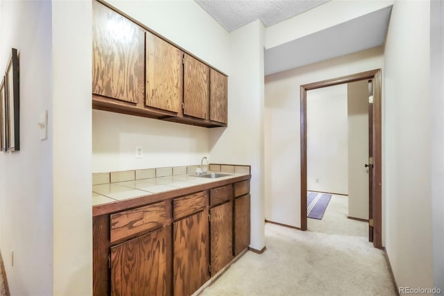 510 Silhouette Way, Monument, CO 80132 - kitchen with light colored carpet, tile counters, and brown cabinets
