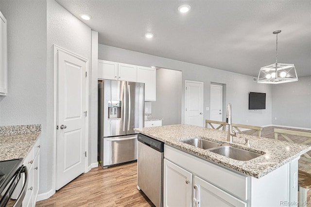 kitchen with white cabinetry, an island with sink, appliances with stainless steel finishes, decorative light fixtures, and sink