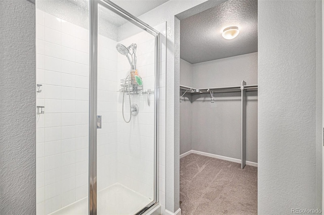 bathroom with a shower with shower door and a textured ceiling