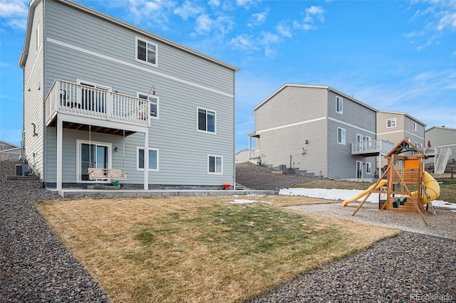 back of property with a playground, a yard, and central air condition unit