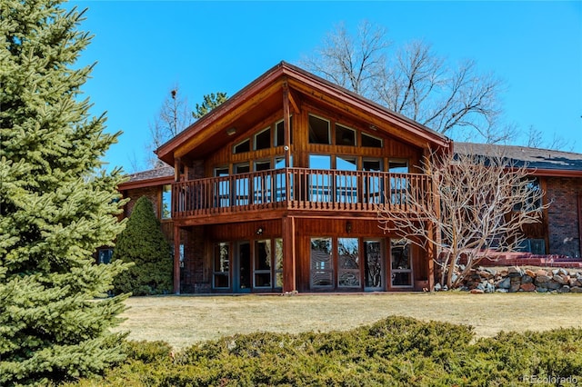 back of house featuring a lawn and a deck