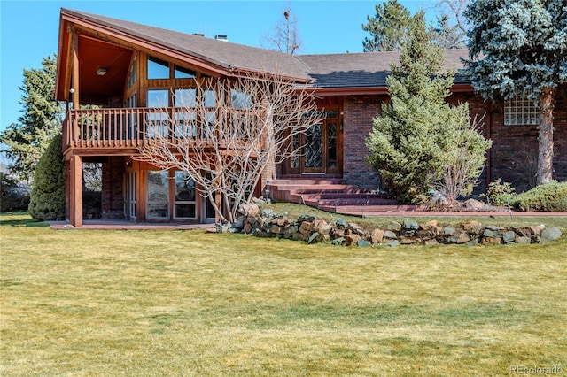 back of property featuring a lawn, brick siding, and a wooden deck