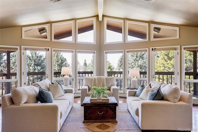 living room with visible vents, wood finished floors, and vaulted ceiling with beams