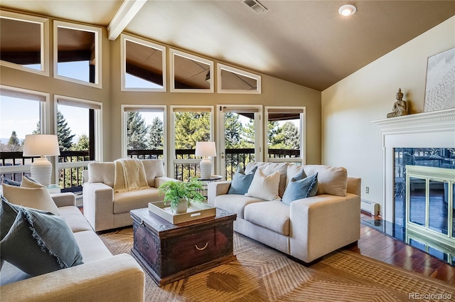 living area featuring visible vents, high vaulted ceiling, wood finished floors, a fireplace, and a baseboard radiator