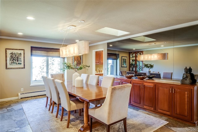 dining space with stone tile flooring, crown molding, a skylight, and a baseboard heating unit