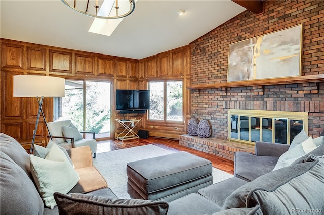 living area with wooden walls, a brick fireplace, brick wall, lofted ceiling with beams, and wood finished floors