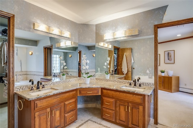 full bath with a sink, a baseboard heating unit, and double vanity