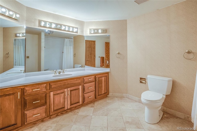 bathroom with vanity, tile patterned floors, toilet, and baseboards