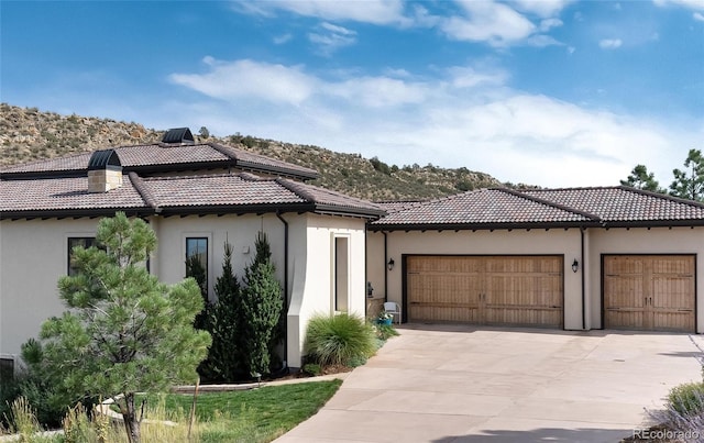 mediterranean / spanish-style house with a mountain view and a garage