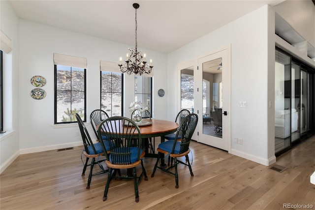 dining room with an inviting chandelier and light wood-type flooring