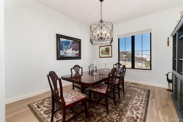 dining area featuring hardwood / wood-style floors and an inviting chandelier