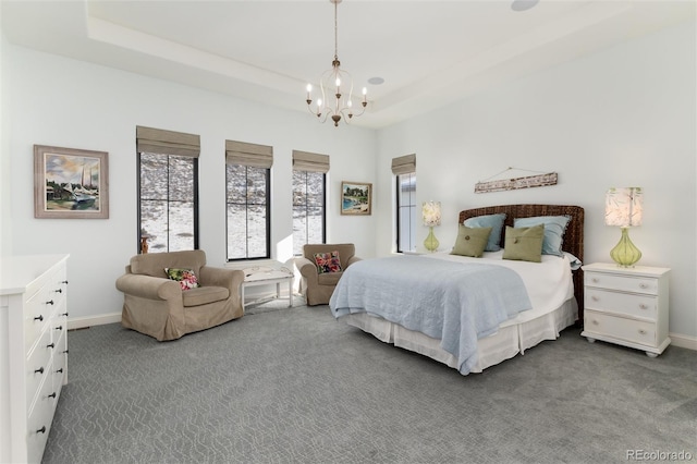 carpeted bedroom featuring a raised ceiling and an inviting chandelier