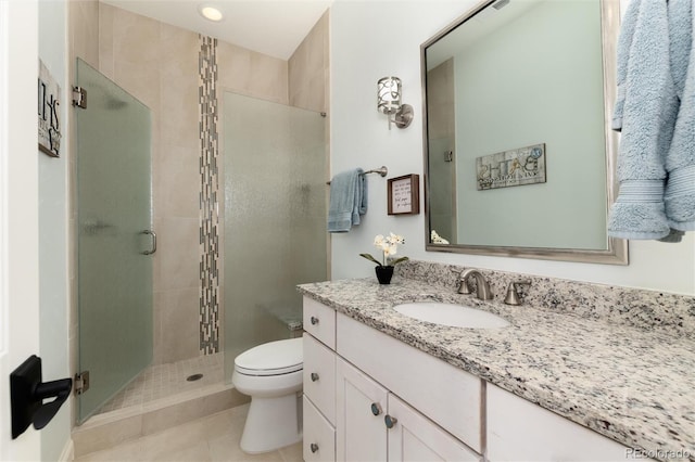 bathroom with toilet, tile patterned flooring, vanity, and walk in shower