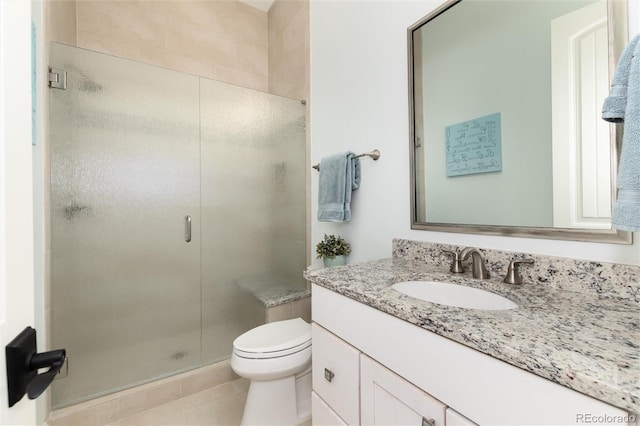 bathroom featuring tile patterned floors, vanity, toilet, and a shower with shower door