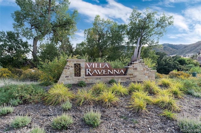 community / neighborhood sign with a mountain view