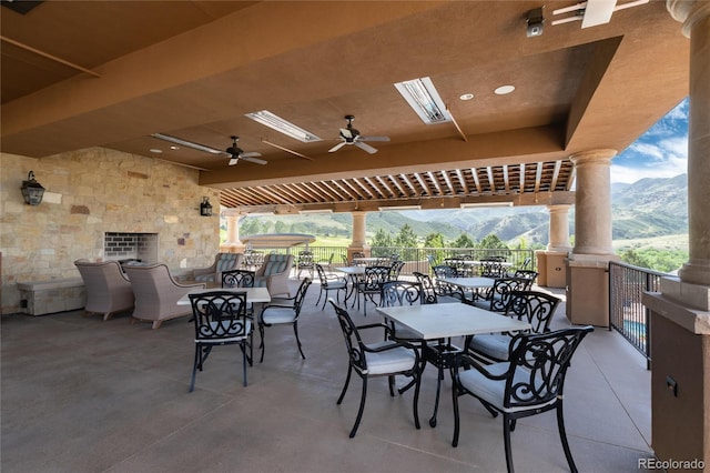 view of patio with a mountain view, a balcony, and ceiling fan