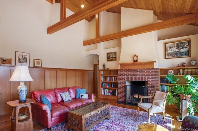 living room featuring wood ceiling, dark hardwood / wood-style flooring, beamed ceiling, a towering ceiling, and a fireplace