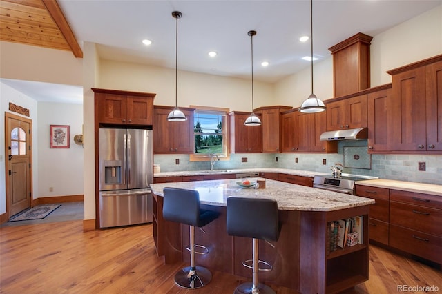 kitchen featuring sink, a center island, light hardwood / wood-style flooring, appliances with stainless steel finishes, and pendant lighting