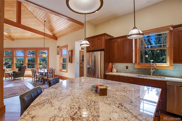 kitchen with stainless steel appliances, sink, pendant lighting, and decorative backsplash