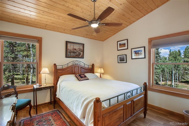 bedroom featuring lofted ceiling, wood ceiling, light wood-type flooring, ceiling fan, and multiple windows