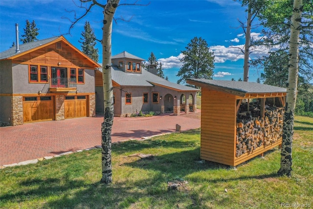 exterior space with a garage and a lawn