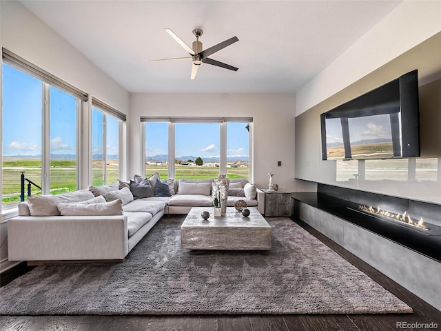 living room featuring dark wood-type flooring and ceiling fan