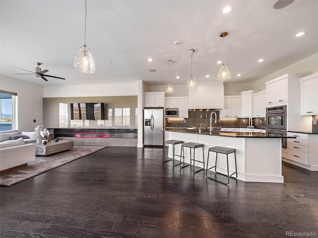 kitchen with pendant lighting, white cabinets, stainless steel appliances, and dark hardwood / wood-style flooring