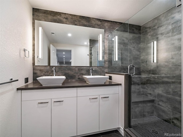 bathroom with vanity, tasteful backsplash, and walk in shower