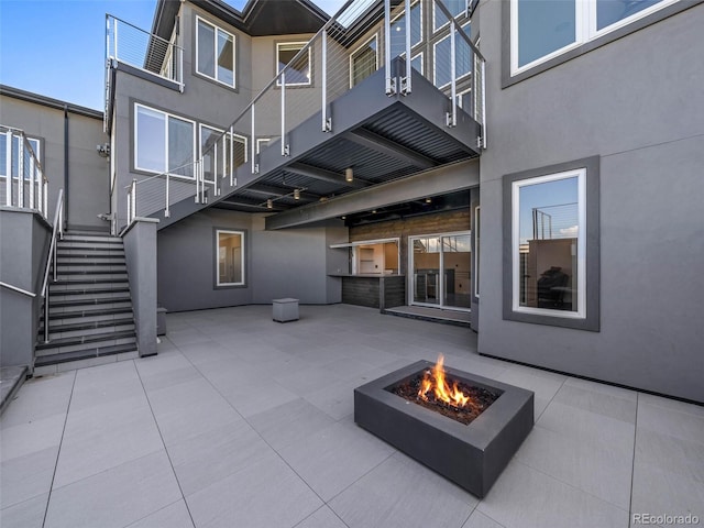 view of patio featuring a balcony and a fire pit