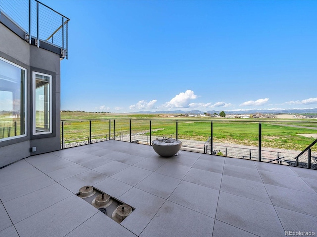 view of patio / terrace featuring a rural view, a balcony, and a mountain view