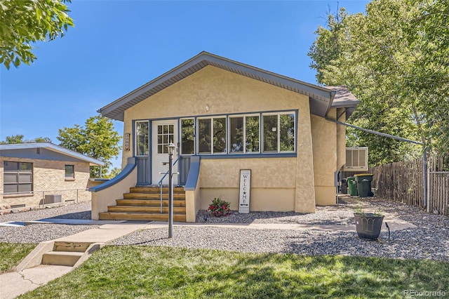 view of front of house with stucco siding, fence, and entry steps