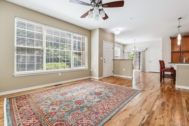 11972 W Long Cir Unit 104, Littleton, CO 80127 - entryway featuring light wood-style flooring, a ceiling fan, and a chandelier