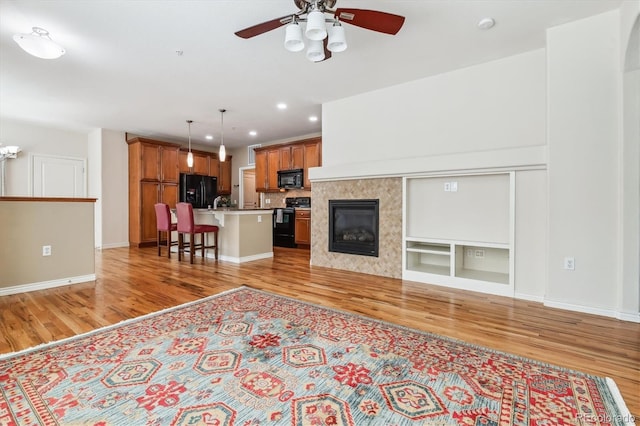 11972 W Long Cir Unit 104, Littleton, CO 80127 - living room featuring light wood-type flooring, recessed lighting, a ceiling fan, and a tile fireplace