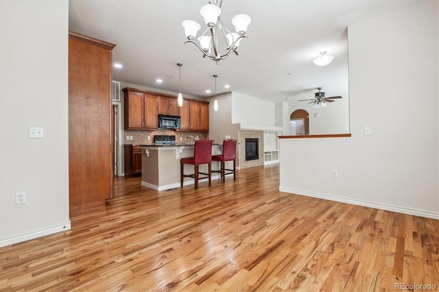 11972 W Long Cir Unit 104, Littleton, CO 80127 - kitchen with black microwave, open floor plan, a kitchen bar, light wood-type flooring, and recessed lighting