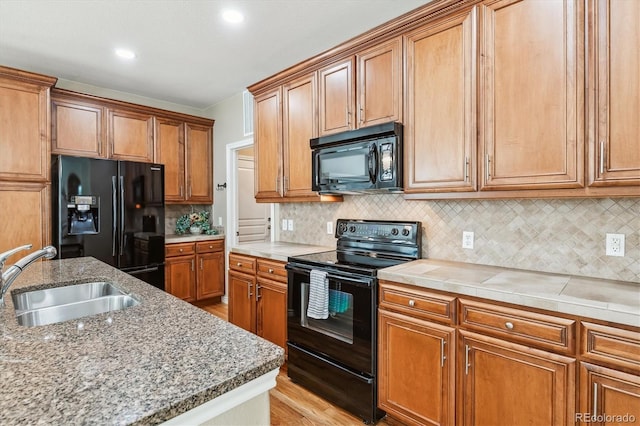 11972 W Long Cir Unit 104, Littleton, CO 80127 - kitchen featuring black appliances, light wood-style flooring, brown cabinets, backsplash, and recessed lighting