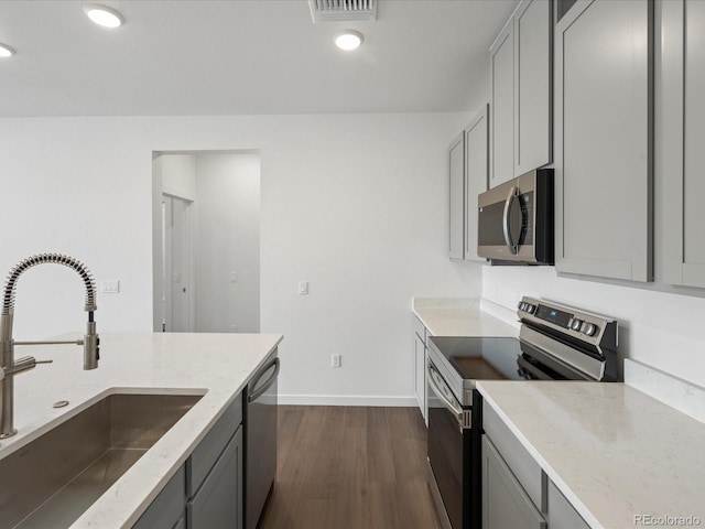 kitchen with stainless steel appliances, sink, dark wood-type flooring, and gray cabinets