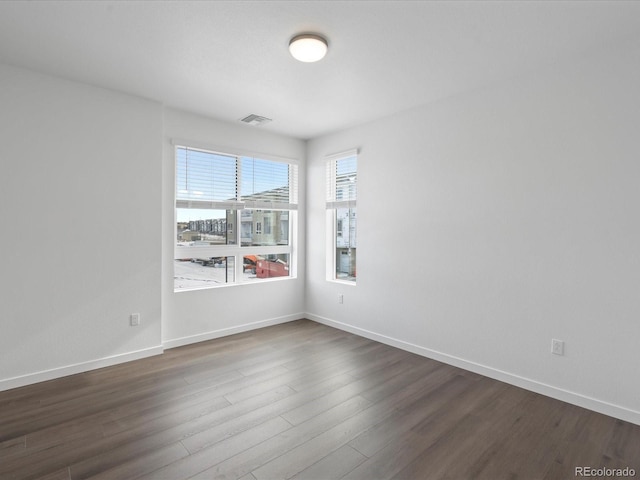 unfurnished room with dark hardwood / wood-style flooring