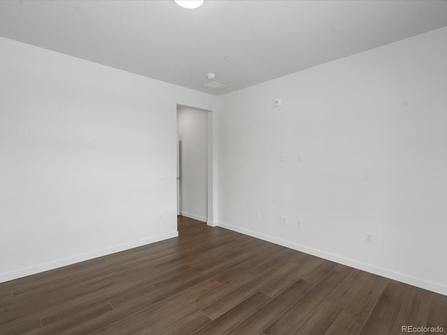 empty room with dark hardwood / wood-style flooring