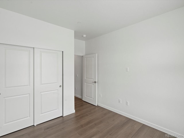 unfurnished bedroom featuring a closet and dark hardwood / wood-style floors