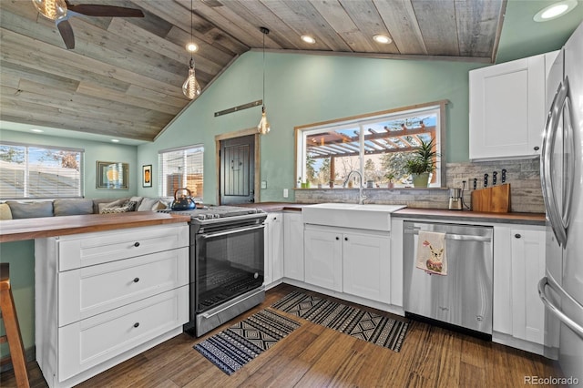 kitchen with dark wood finished floors, a sink, wooden ceiling, open floor plan, and stainless steel appliances