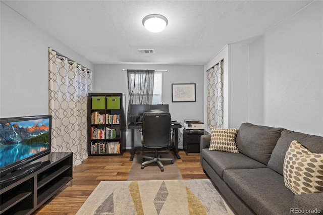 home office featuring wood finished floors and visible vents