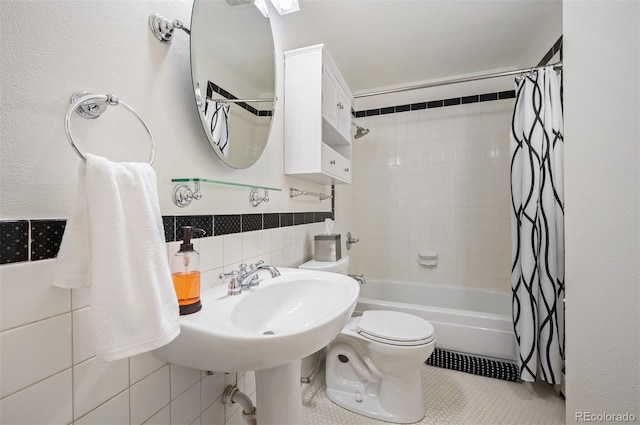 bathroom with shower / bath combo, toilet, tile patterned floors, tile walls, and tasteful backsplash