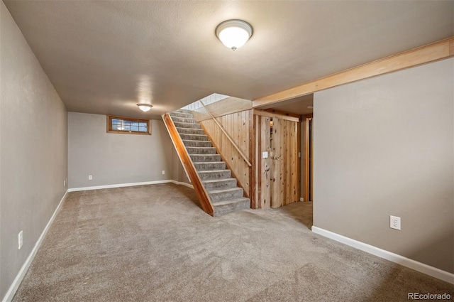 basement with stairs, carpet, and baseboards