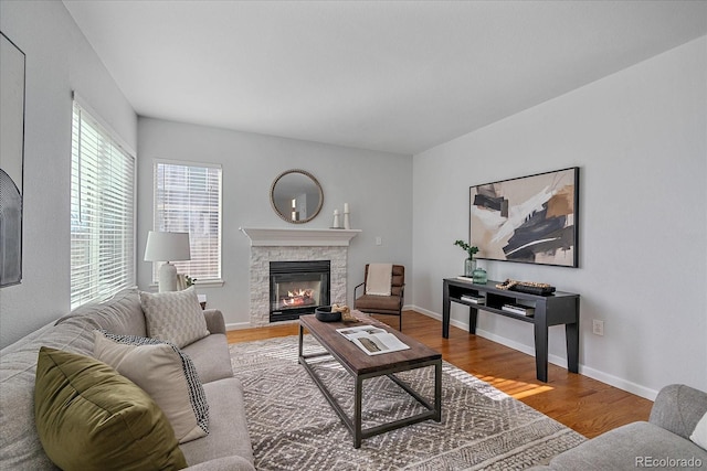 living room with a fireplace, wood finished floors, and baseboards