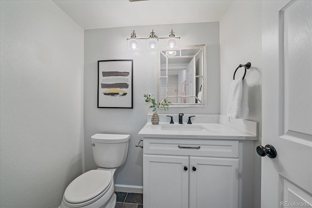 bathroom featuring tile patterned flooring, vanity, toilet, and baseboards