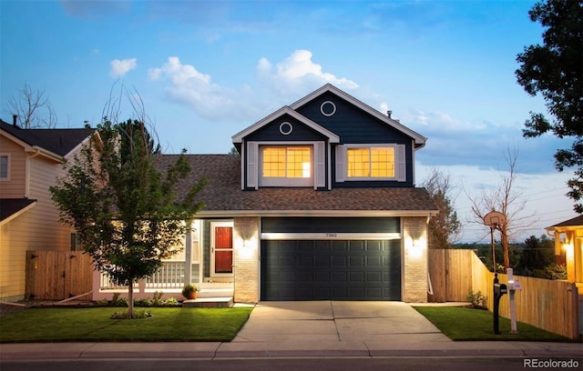 traditional home featuring brick siding, concrete driveway, an attached garage, a front yard, and fence