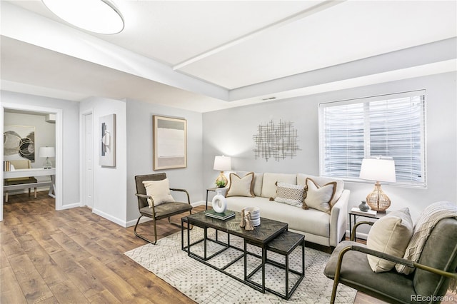 living area featuring visible vents, baseboards, and wood finished floors