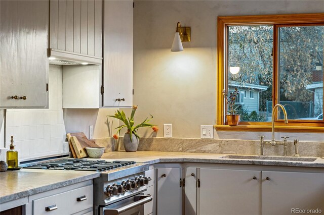 8120 W 54th Pl, Arvada, CO 80002 - kitchen featuring stainless steel range, a sink, light countertops, white cabinetry, and tasteful backsplash