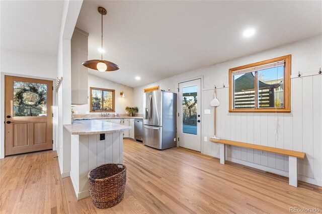 8120 W 54th Pl, Arvada, CO 80002 - kitchen featuring appliances with stainless steel finishes, light countertops, light wood-type flooring, a peninsula, and vaulted ceiling